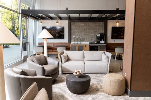 a living room with a couch and chairs and a kitchen